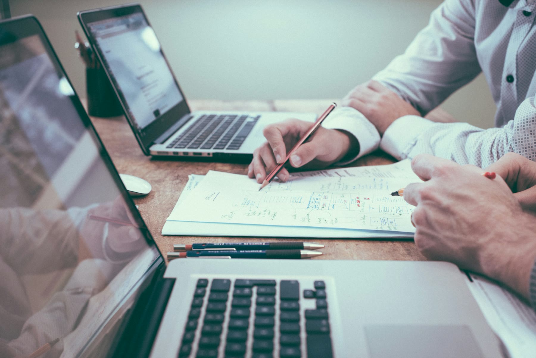 Papers, laptop, and a calculator on a desk — the monthly Zapier bill a one-person shop actually pays